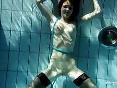 Beautiful slim brunette swims in lowering stockings