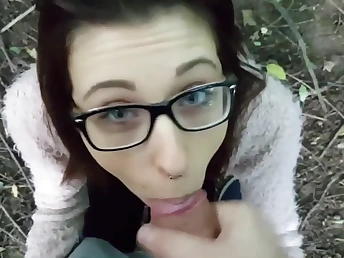 Geeky brunette is on her knees swallowing a dick about the forest